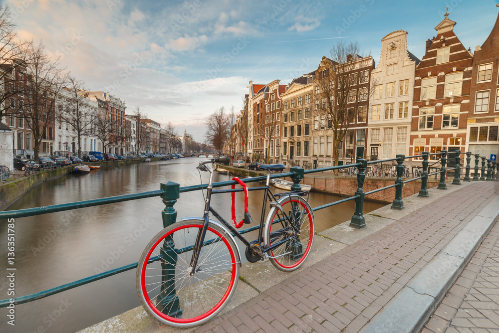 Red bicycle parked against the bridge railing at the Keizersgracht at Amsterdam 