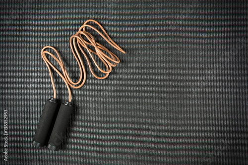 Jump rope on black yoga mat
