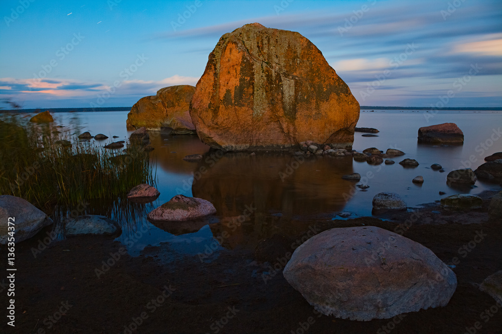 Tranquil view of sunset with stones along a shore of the Baltic Sea in Estonia.