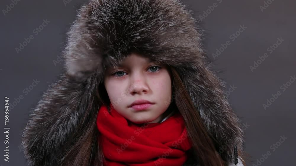 Beautiful little girl in a fur hat posing in studio. Video resolution of 4K Beautiful little girl in a fur hat posing in studio. Video resolution of 4K