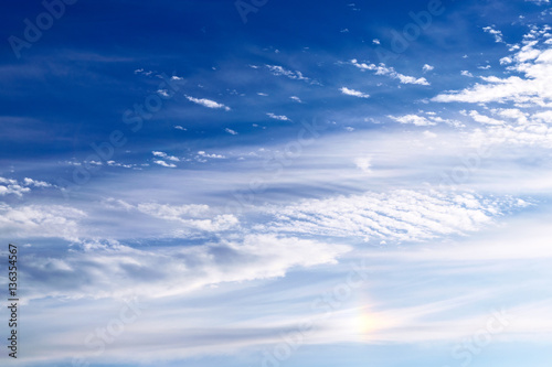Fototapeta Naklejka Na Ścianę i Meble -  Light cirrus clouds against the blue sky with an element of the solar halo.