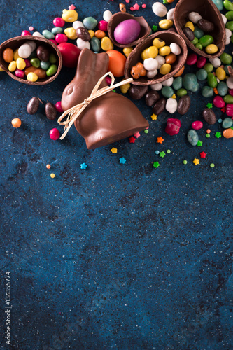 Delicious chocolate easter eggs ,bunny and sweets on dark blue background