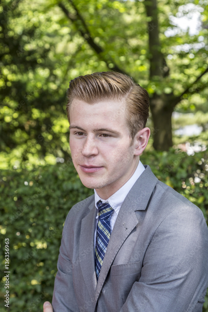 elegant dressed teenage boy poses in the park elegant dressed teenage boy poses in the park