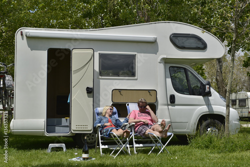 couple sitting in front of their motor home