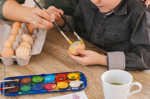 Mother and son painting on Easter eggs