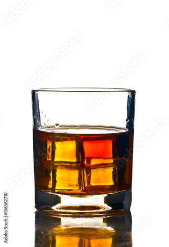 glass of whiskey on a white background with symmetrical cubes of ice that glow