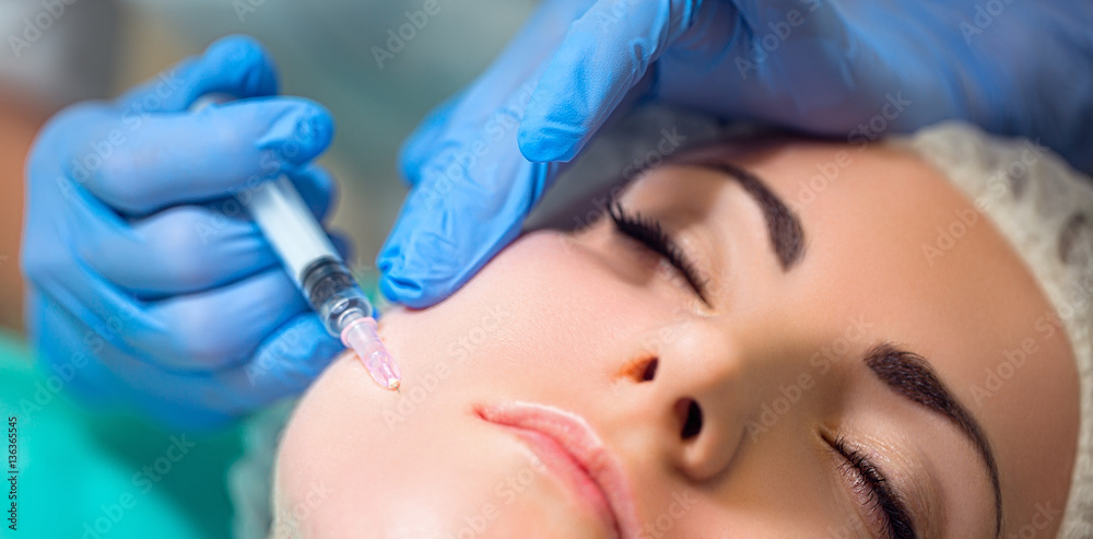 Receiving mesotherapy procedure, cosmetology. Beautician doing procedure on woman. Skincare concept.
