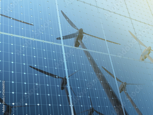 Wind turbine reflected on the solar panels against clear blue sk