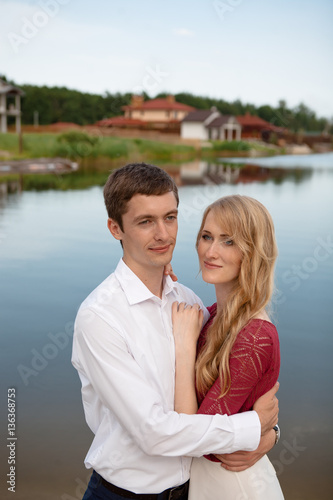 Wedding couple standing and hugging near lake