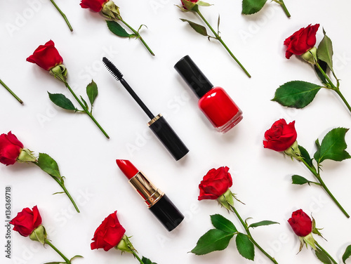 Colorful composition with red bright roses and woman accessories. Flat lay on white table, top view