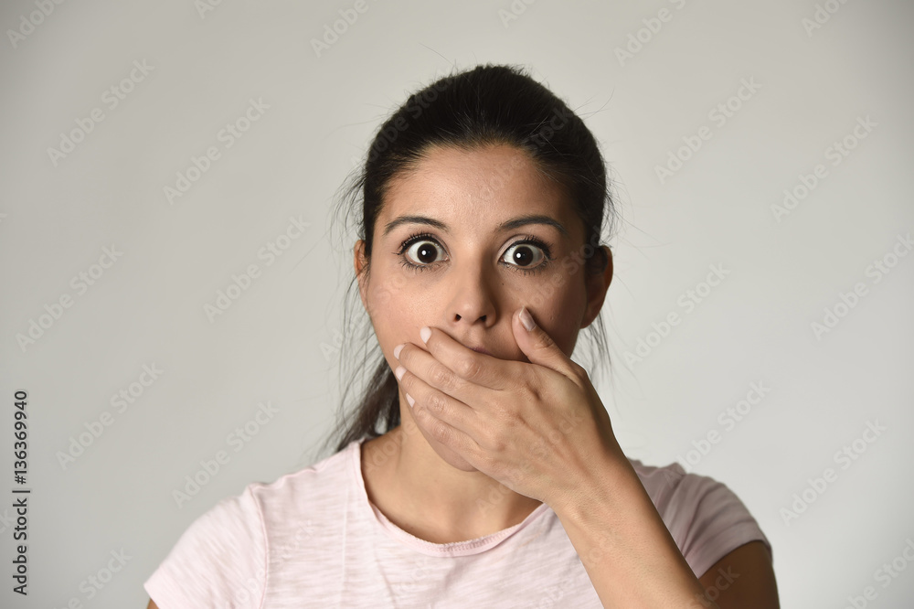 young beautiful Spanish surprised woman amazed in shock and surprise covering mouth young beautiful Spanish surprised woman amazed in shock and surprise covering mouth