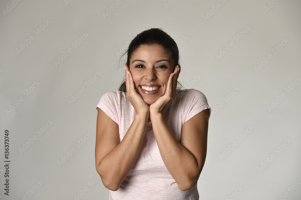 portrait of young beautiful and happy Latin woman holding face with hands with big toothy smile portrait of young beautiful and happy Latin woman holding face with hands with big toothy smile