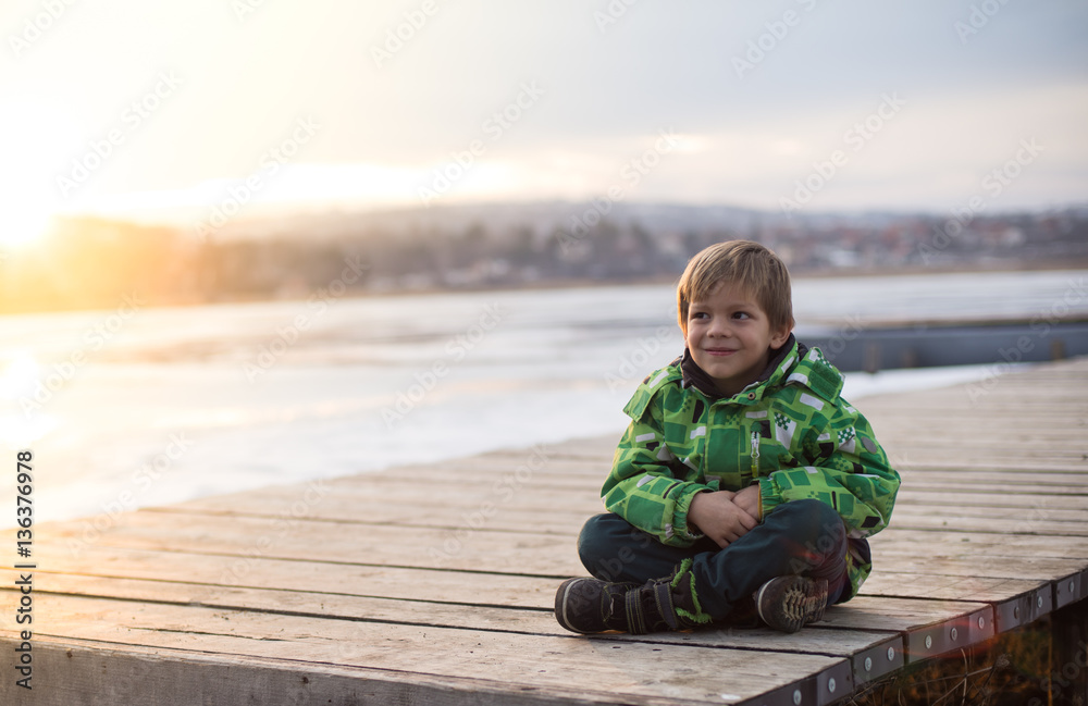 Naklejka premium Little boy in a winter landscape