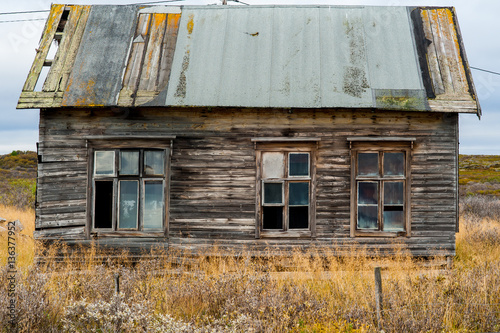 Obraz na plátne Old wooden decrepit house in need of repair with damaged roof and windows