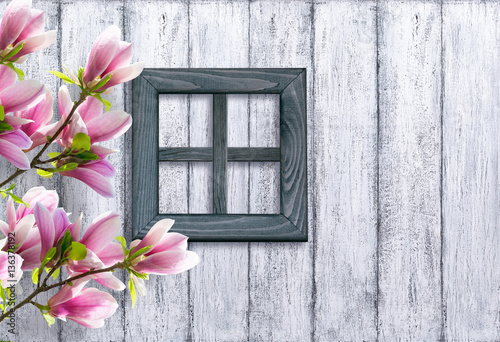 Magnolia flowers on background of wooden wall and window in rust