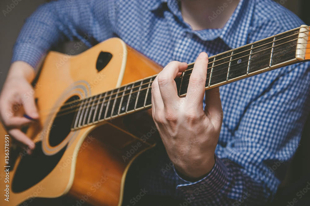 Fototapeta premium Close up of guitarist hand playing guitar