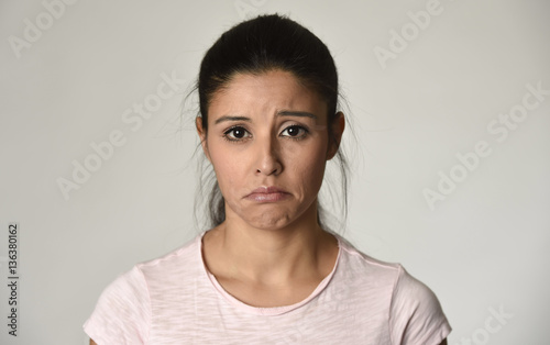 young beautiful hispanic sad woman serious and concerned in worried depressed facial expression