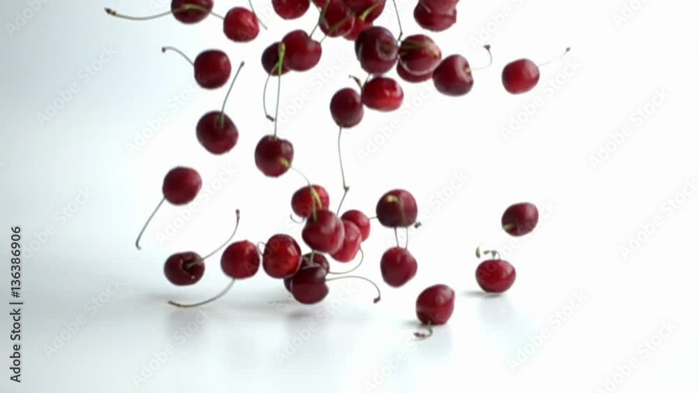 cherries falling on white background in slow motion 