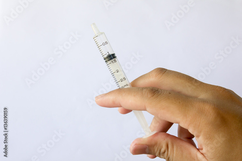 Man hold the plastic syringe on white background