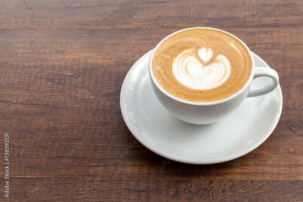 Coffee cup of latte art on wooden background with copy space