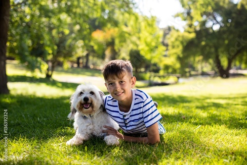 Portrait of boy with dog in park