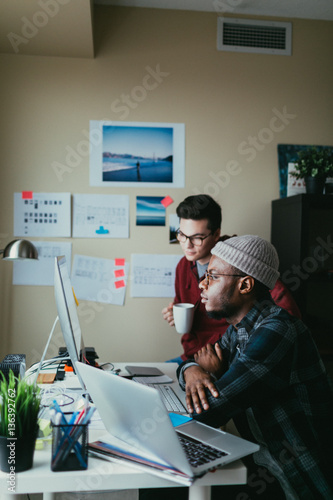 Two People Collaborating Around A Computer