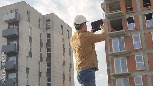 Contruction manager make photo of construction by tablet.
