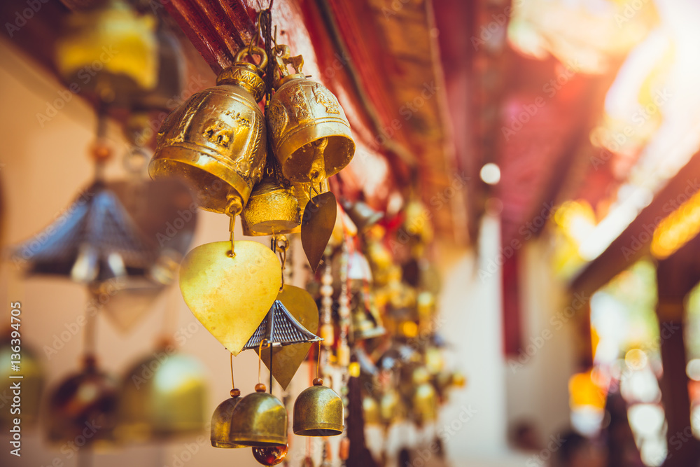 Naklejka premium Bell in Thailand temple. Buddha worship copper golden small Buddhist bell hanging at chapel.