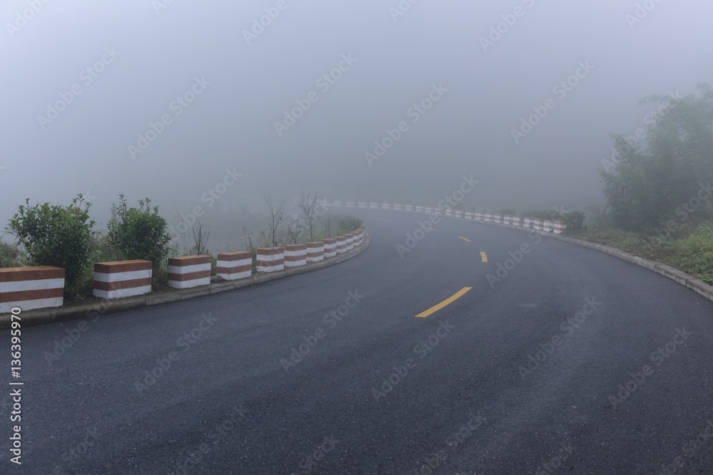 Road in heavy fog. A crooked road turn into mist. Full of mysterious, misty and dangerous feelings.