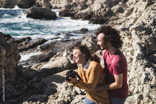 Woman photographing landscape and happy laugh with loved man