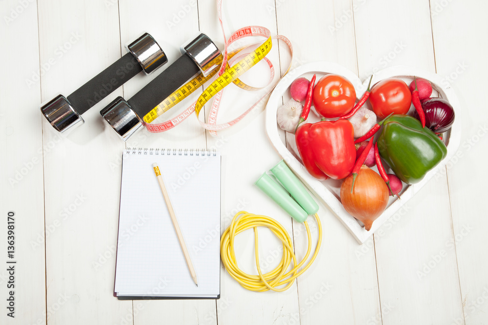 Sport and diet. Healthy lifestyle. Vegetables, dumbbells notebook. Peppers,  tomatoes, garlic, onion radish in a heart on white background Stock Photo |  Adobe Stock