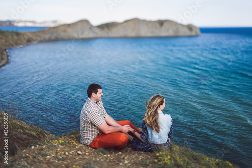 Couple relaxing by the sea with amazing mountain view. Jeans jacket © Oleg Breslavtsev