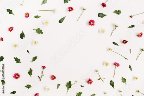 Frame wreath with red and white wildflowers, green leaves, branches on white background. Flat lay, top view. Flower background.