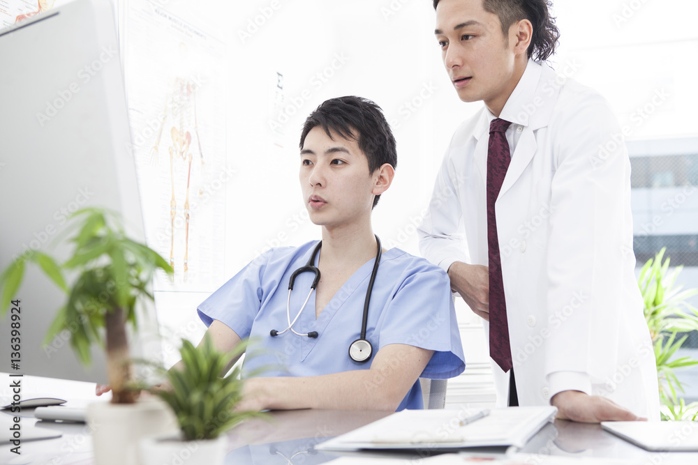 Two male doctors are talking at the examination room Two male doctors are talking at the examination room