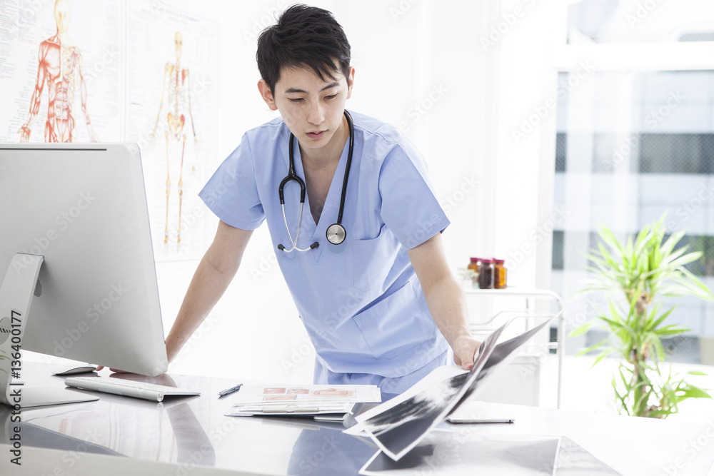 The doctor is looking at the x - ray picture in the examination room The doctor is looking at the x - ray picture in the examination room