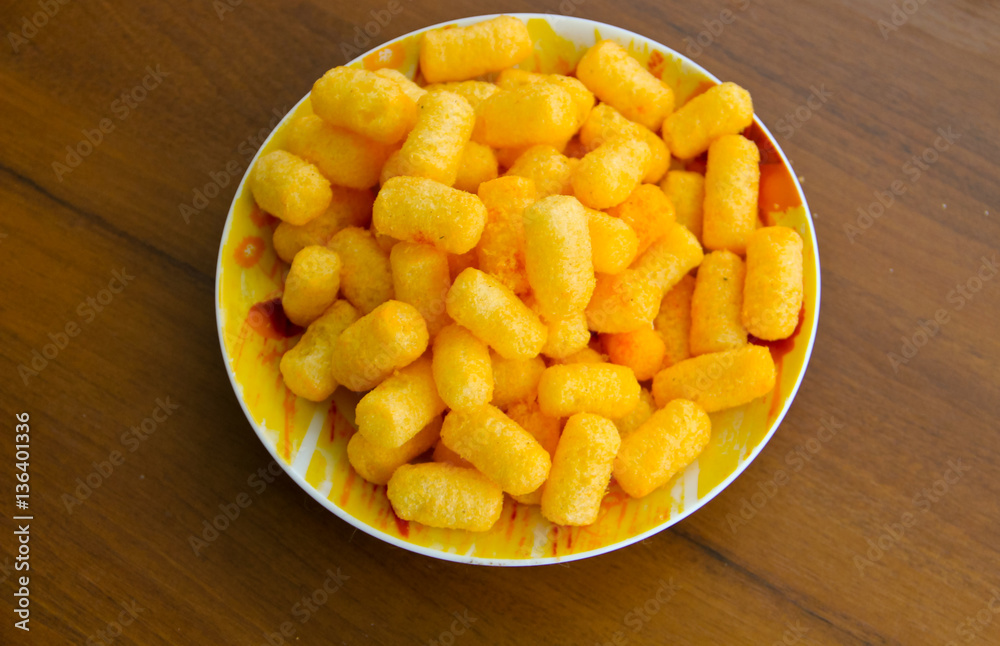 Corn sticks in bowl on wooden table