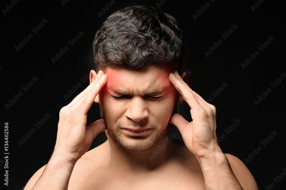 Young man suffering from head ache on black background. Health care concept Young man suffering from head ache on black background. Health care concept