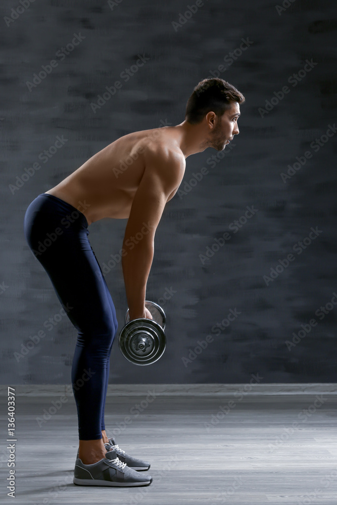Obraz premium Sporty man doing exercises with barbell indoors