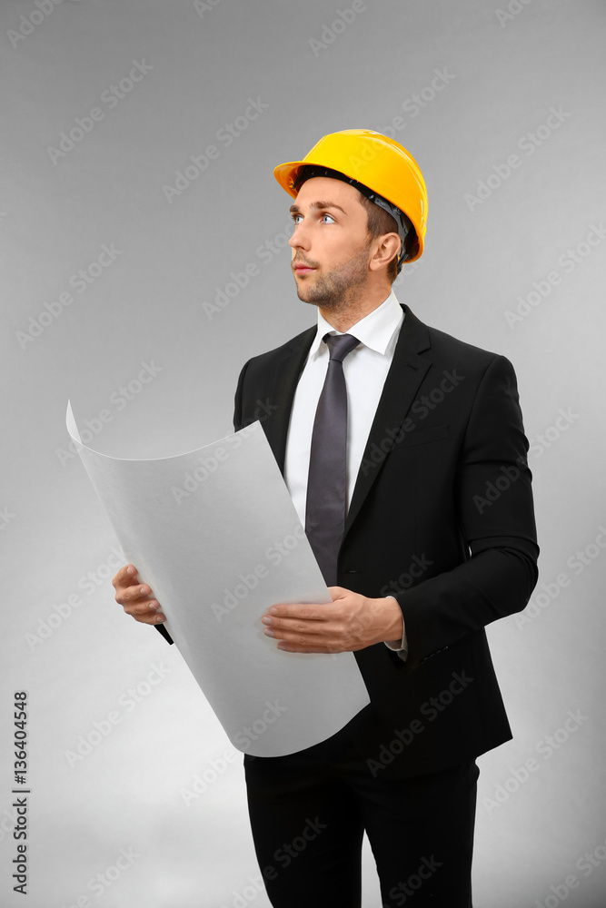Handsome engineer with drawing on light background Handsome engineer with drawing on light background