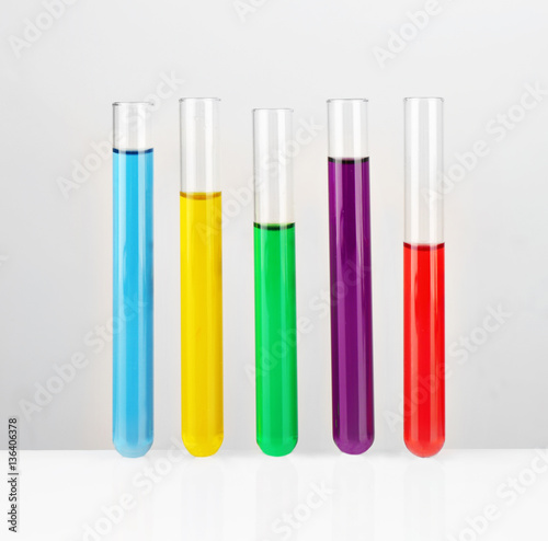 Test tubes with colourful samples on white background