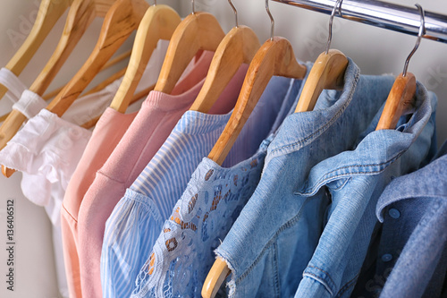 Closeup of hangers with different clothes in wardrobe