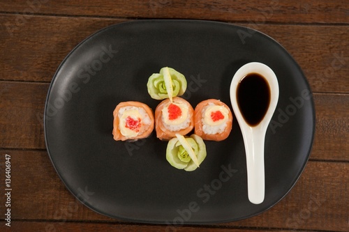 Three nigiri sushi served with soy sauce in black plate