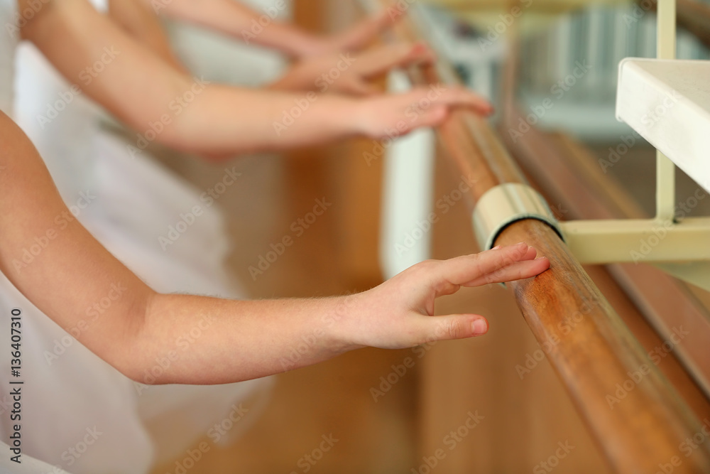 Obraz premium Group of little ballerinas practicing ballet using bar at class, closeup