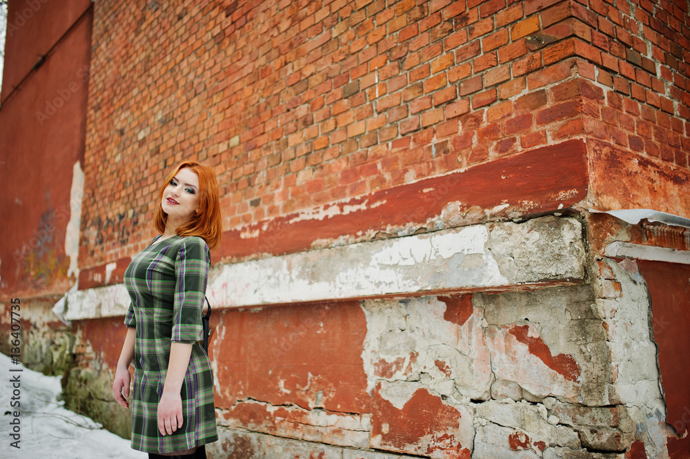 An outdoor portrait of a young pretty girl with red hair wearing