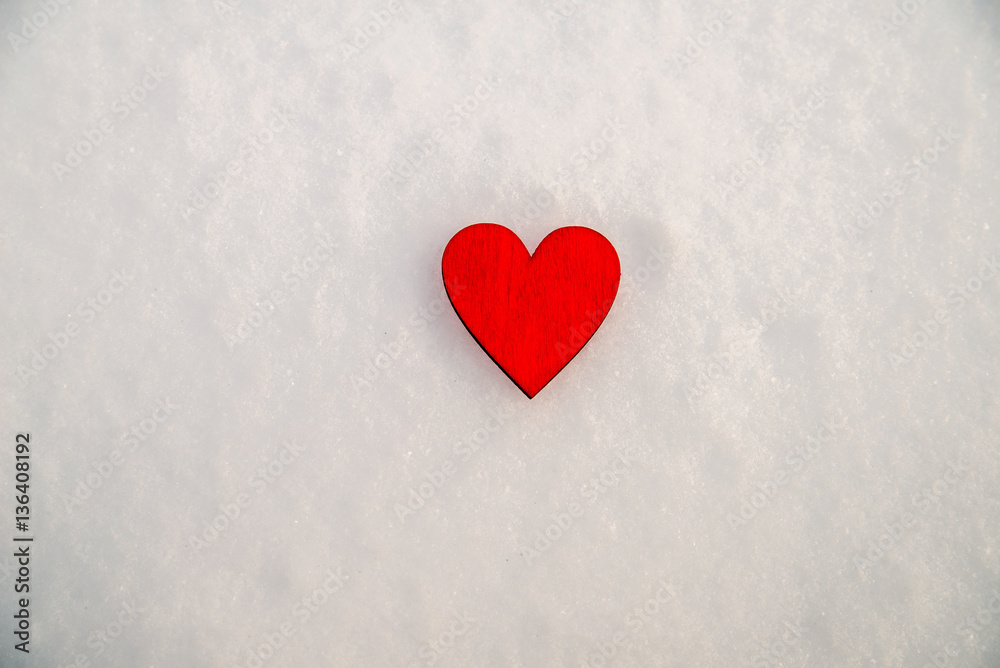     romantic background red heart lies on the snow 