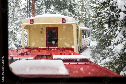 Vintage steam train rides through the snow-covered pine forest. Georgia Borjomi-Bakuriani Cuckoo ( Kukushka ) route . Thirst for wandering photo