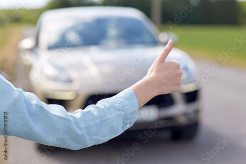 woman hitchhiking and stopping car with thumbs up