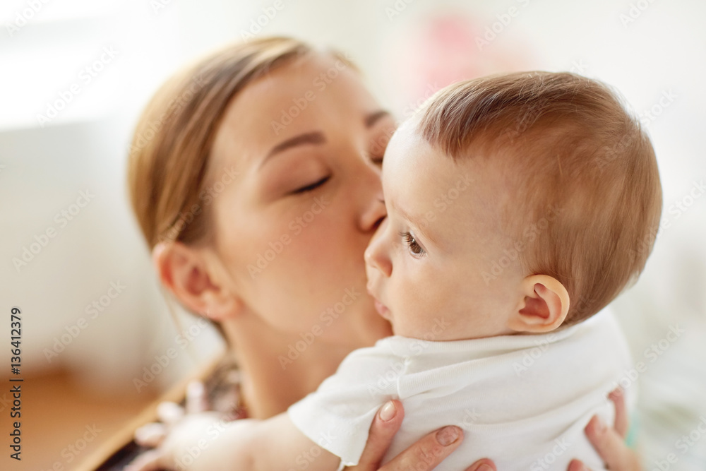 happy young mother kissing little baby at home happy young mother kissing little baby at home