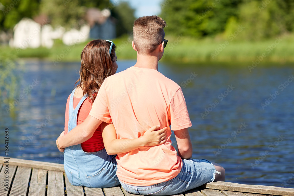 happy teenage couple hugging on river summer berth