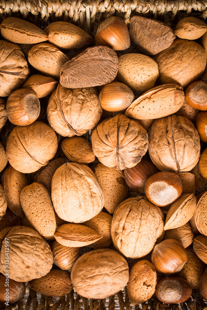 delicious assortment of nuts in a woven basket on wooden backgro delicious assortment of nuts in a woven basket on wooden backgro